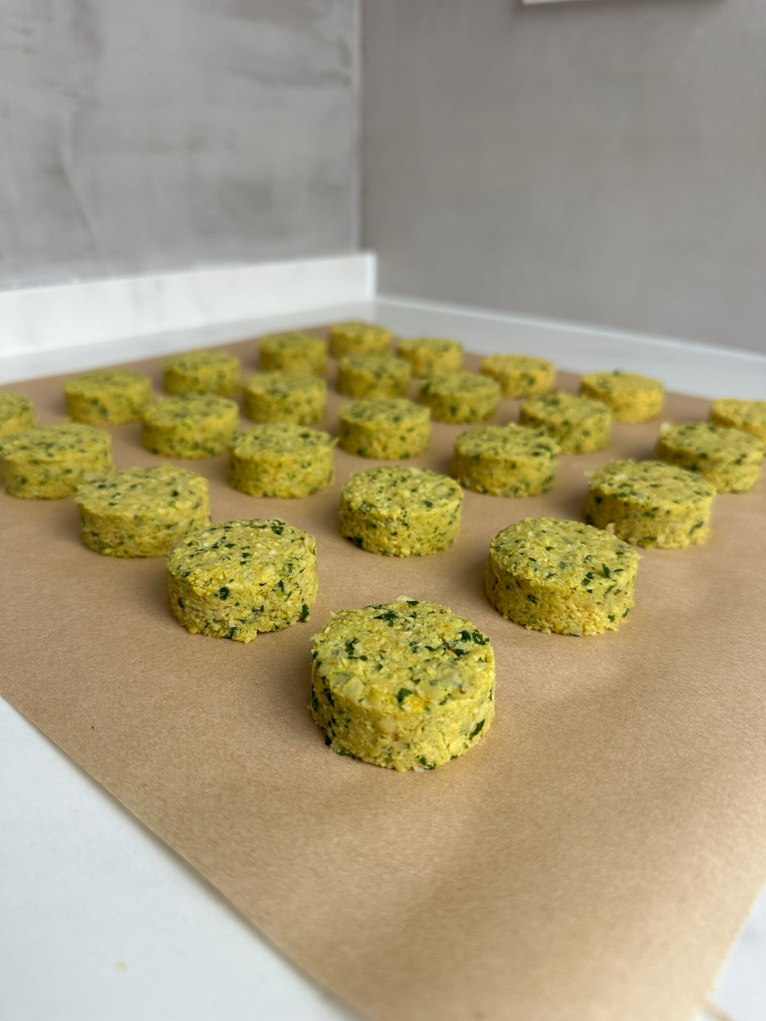 Falafel being formed by hand on a tray